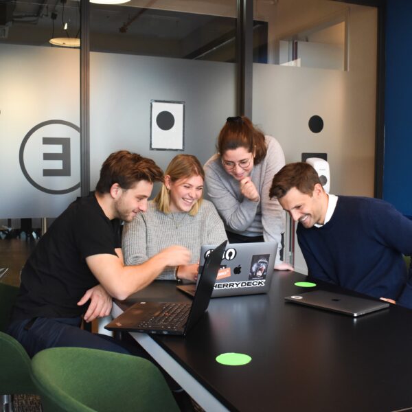 Group of people smiling at a laptop