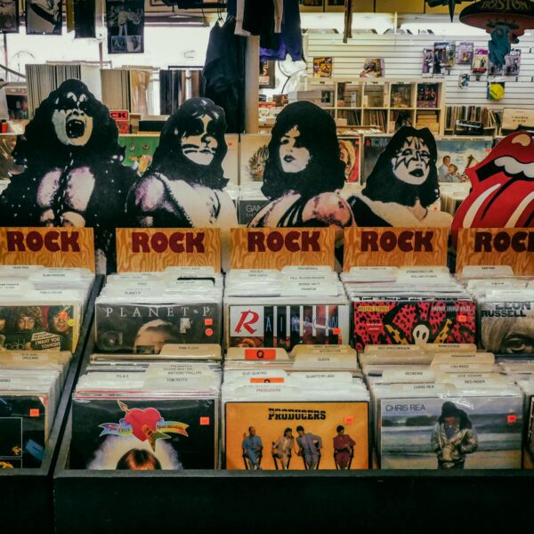A shelf of rock music vinyl records and images of the bandmembers of Kiss at a music store