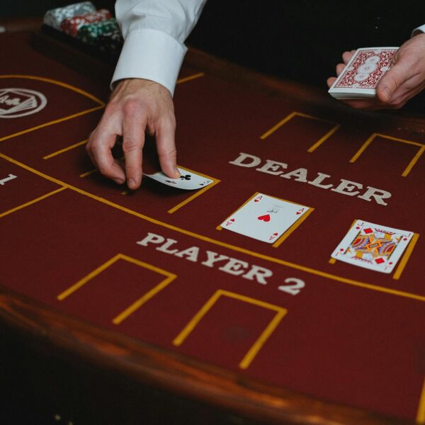 A croupier displaying cards on a maroon card table